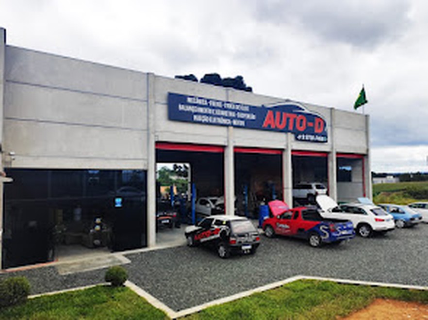 Fachada da Auto-D Centro Automotivo em São Bento do Sul, com veículos estacionados na área externa da oficina