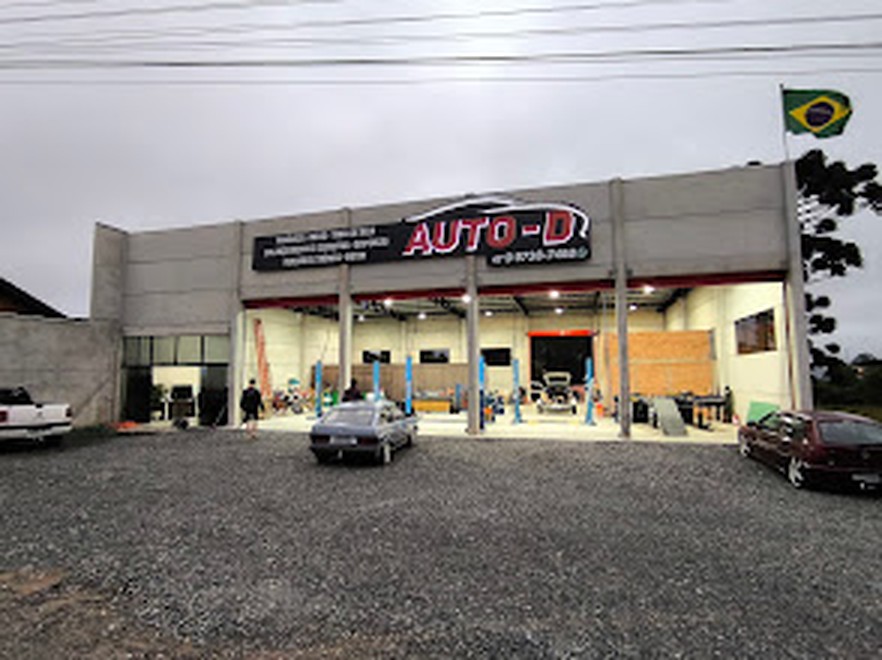 Fachada da Auto-D Centro Automotivo iluminada ao entardecer